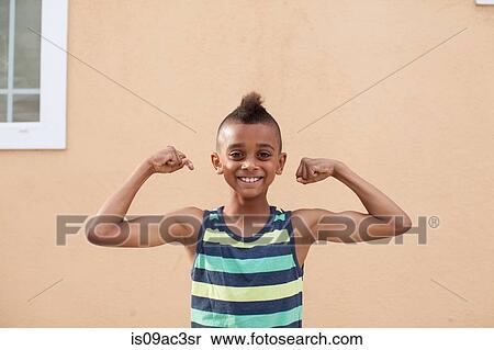 Stock Photography - Portrait of boy flexing muscles. Fotosearch