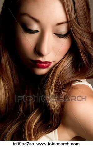 Stock Image - Portrait of brunette woman looking down. Fotosearch