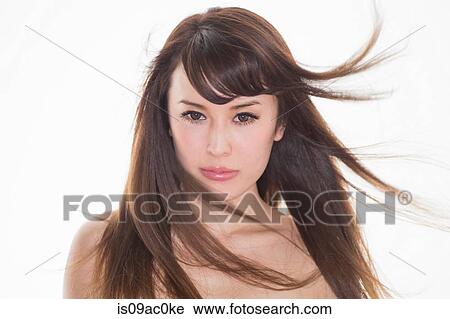 Stock Image - Portrait of brunette woman with windswept hair. Fotosearch