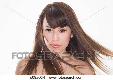 Stock Image - Portrait of brunette woman with windswept hair. Fotosearch