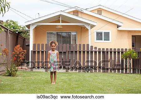 Stock Image - Portrait of girl in front of house. Fotosearch