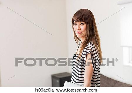 Stock Image - Portrait of woman wearing striped top. Fotosearch