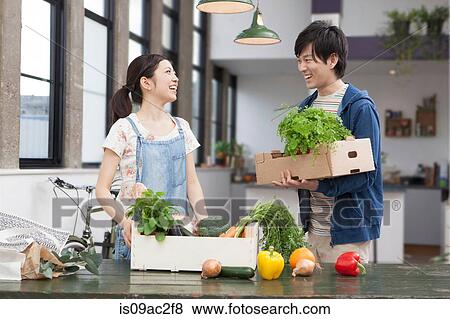 Portrait of young couple in kitchen with herbs and vegetables View Large Photo Image Stock Photo - Portrait of young couple in kitchen with herbs and vegetables. Fotosearch