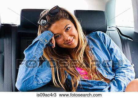 Stock Image - Portrait of young woman in car. Fotosearch