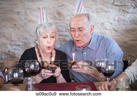 Senior couple blowing out birthday candles View Large Photo Image Stock Photo - Senior couple blowing out birthday candles. Fotosearch