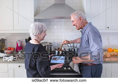 Senior couple preparing food at home View Large Photo Image Stock Image - Senior couple preparing food at home. Fotosearch