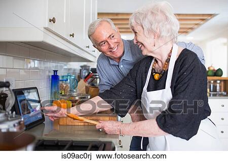 Senior couple preparing food at home View Large Photo Image Stock Image - Senior couple preparing food at home. Fotosearch