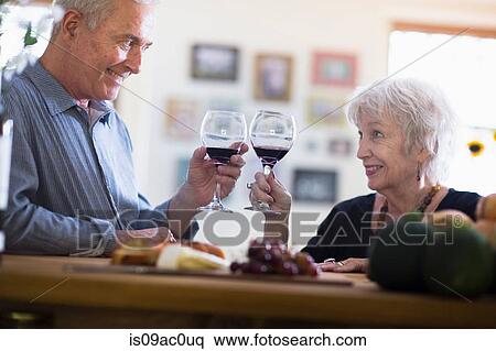 Stock Photography - Senior couple toasting with red wine. Fotosearch