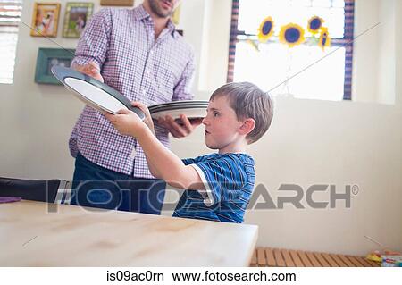 Son setting the table with father View Large Photo Image Picture - Son setting the table with father. Fotosearch