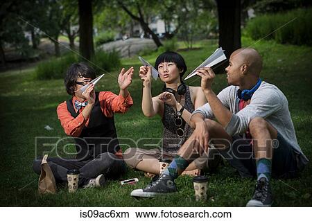 Three friends holding paper planes in park View Large Photo Image Picture - Three friends holding paper planes in park. Fotosearch