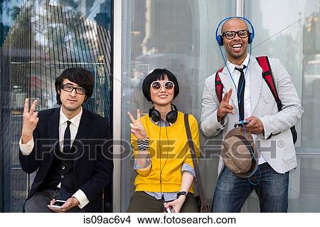 Picture - Three friends making victory sign. Fotosearch