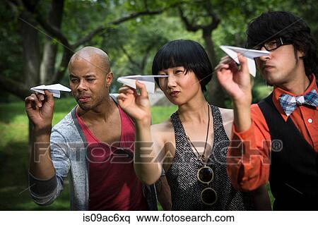 Three friends throwing paper planes in park View Large Photo Image Stock Photography - Three friends throwing paper planes in park. Fotosearch