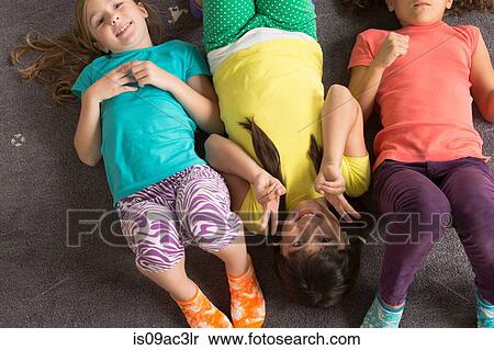 Three girls lying on floor wearing bright clothes View Large Photo Image Stock Photography - Three girls lying on floor wearing bright clothes. Fotosearch
