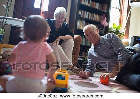 Stock Photo - Toddler girl playing with grandparents. Fotosearch
