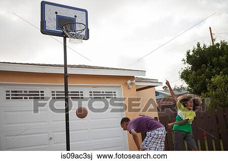 Stock Image - Two brothers playing basketball. Fotosearch