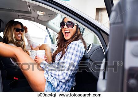 Two female friends in car with takeaway drinks View Large Photo Image Stock Photograph - Two female friends in car with takeaway drinks. Fotosearch