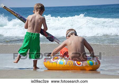 Two young brothers playing on beach View Large Photo Image Stock Image - Two young brothers playing on beach. Fotosearch