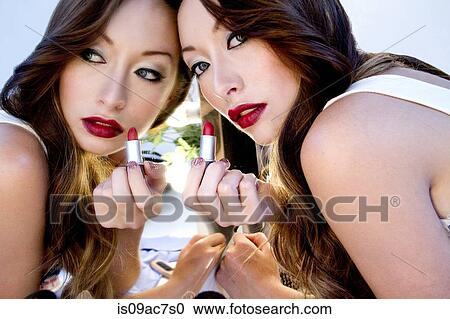Woman applying lipstick in mirror View Large Photo Image Stock Image - Woman applying lipstick in mirror. Fotosearch