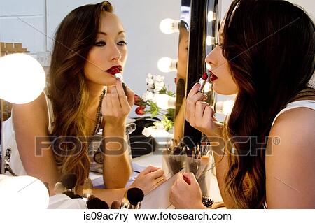 Woman applying lipstick in mirror View Large Photo Image Stock Photo - Woman applying lipstick in mirror. Fotosearch