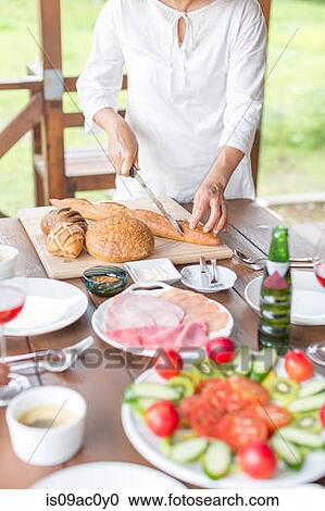 Woman cutting baguette View Large Photo Image Stock Image - Woman cutting baguette. Fotosearch