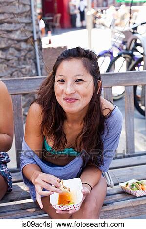 Stock Image - Woman eating takeaway food, Hermosa Beach, California, USA. Fotosearch