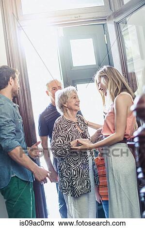 Woman greeting parents in hallway View Large Photo Image Stock Photo - Woman greeting parents in hallway. Fotosearch