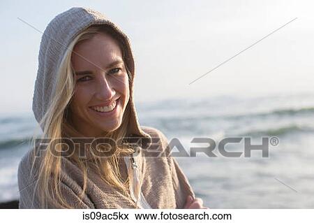 Stock Photo - Woman in hoodie on beach. Fotosearch