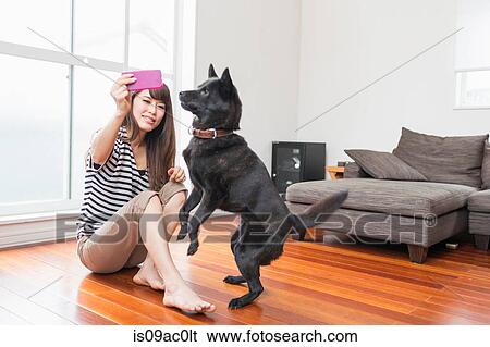 Stock Photograph - Woman photographing self with dog. Fotosearch