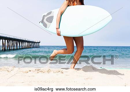 Woman running with surfboard, Hermosa Beach, California, USA View Large Photo Image Stock Image - Woman running with surfboard, Hermosa Beach, California, USA. Fotosearch