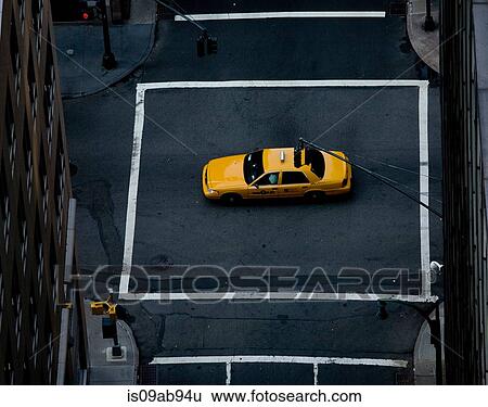 Stock Photograph - Yellow cab in middle of crossroad, New York, New York State, USA. Fotosearch