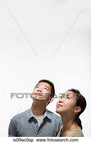 Stock Photography - Young adults looking up. Fotosearch