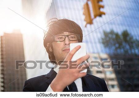 Young businessman using smartphone View Large Photo Image Stock Image - Young businessman using smartphone. Fotosearch