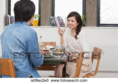 Stock Image - Young couple sharing meal at table. Fotosearch