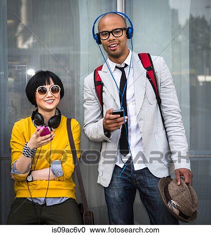 Stock Image - Young couple with mp3 players. Fotosearch