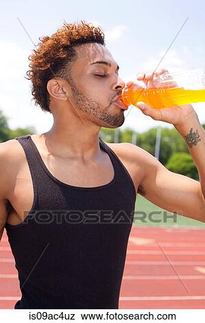 Young man drinking refreshing drink View Large Photo Image Stock Photo - Young man drinking refreshing drink. Fotosearch