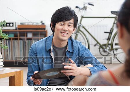 Stock Photo - Young man holding vinyl record. Fotosearch