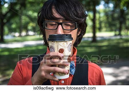 Young man inhaling coffee from disposable cup View Large Photo Image Stock Image - Young man inhaling coffee from disposable cup. Fotosearch