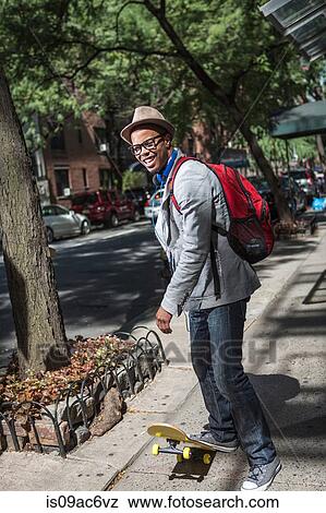 Young man on skateboard on pavement View Large Photo Image Stock Photo - Young man on skateboard on pavement. Fotosearch