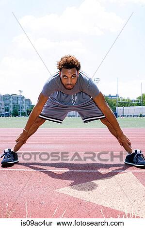 Young man stretching on running track View Large Photo Image Stock Photography - Young man stretching on running track. Fotosearch