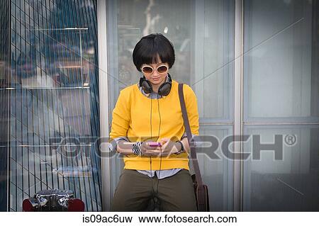 Young woman by window using mp3 player View Large Photo Image Stock Photo - Young woman by window using mp3 player. Fotosearch