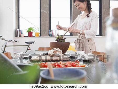 Young woman preparing meal at table View Large Photo Image Stock Photograph - Young woman preparing meal at table. Fotosearch
