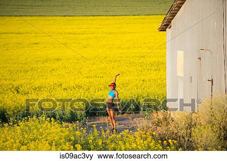 Young woman runner stretching in field of oil seed rape View Large Photo Image Stock Photo - Young woman runner stretching in field of oil seed rape. Fotosearch