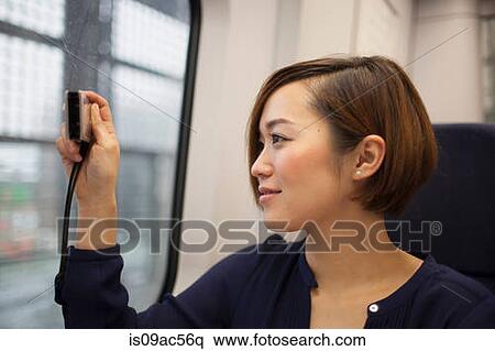 Young woman taking photo through train window View Large Photo Image Stock Photography - Young woman taking photo through train window. Fotosearch