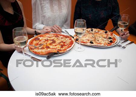 Young women eating pizza in restaurant View Large Photo Image Stock Image - Young women eating pizza in restaurant. Fotosearch
