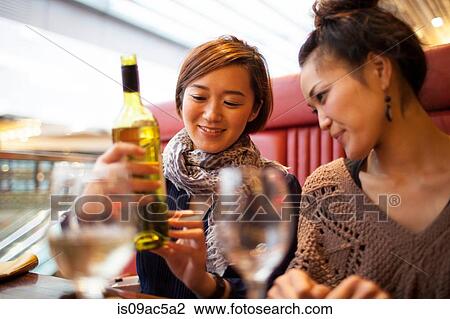 Young women holding wine bottle View Large Photo Image Stock Image - Young women holding wine bottle. Fotosearch