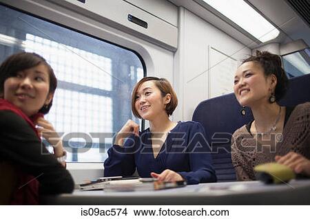 Young women talking on train View Large Photo Image Picture - Young women talking on train. Fotosearch