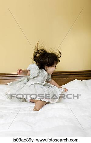 Baby girl unsteady on bed View Large Photo Image Stock Photo - Baby girl unsteady on bed. Fotosearch