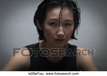 Stock Photograph - Close up studio portrait of serious young woman. Fotosearch