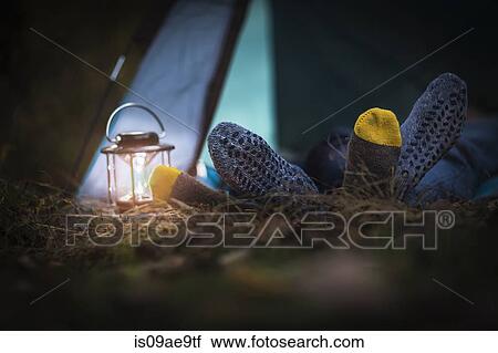 Stock Image - Couple lying in tent - feet together. Fotosearch