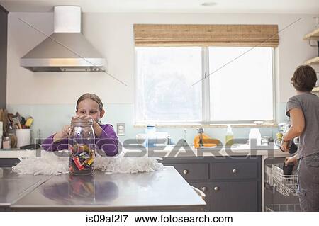 Daughter secretly getting biscuit from biscuit barrel View Large Photo Image Stock Photo - Daughter secretly getting biscuit from biscuit barrel. Fotosearch